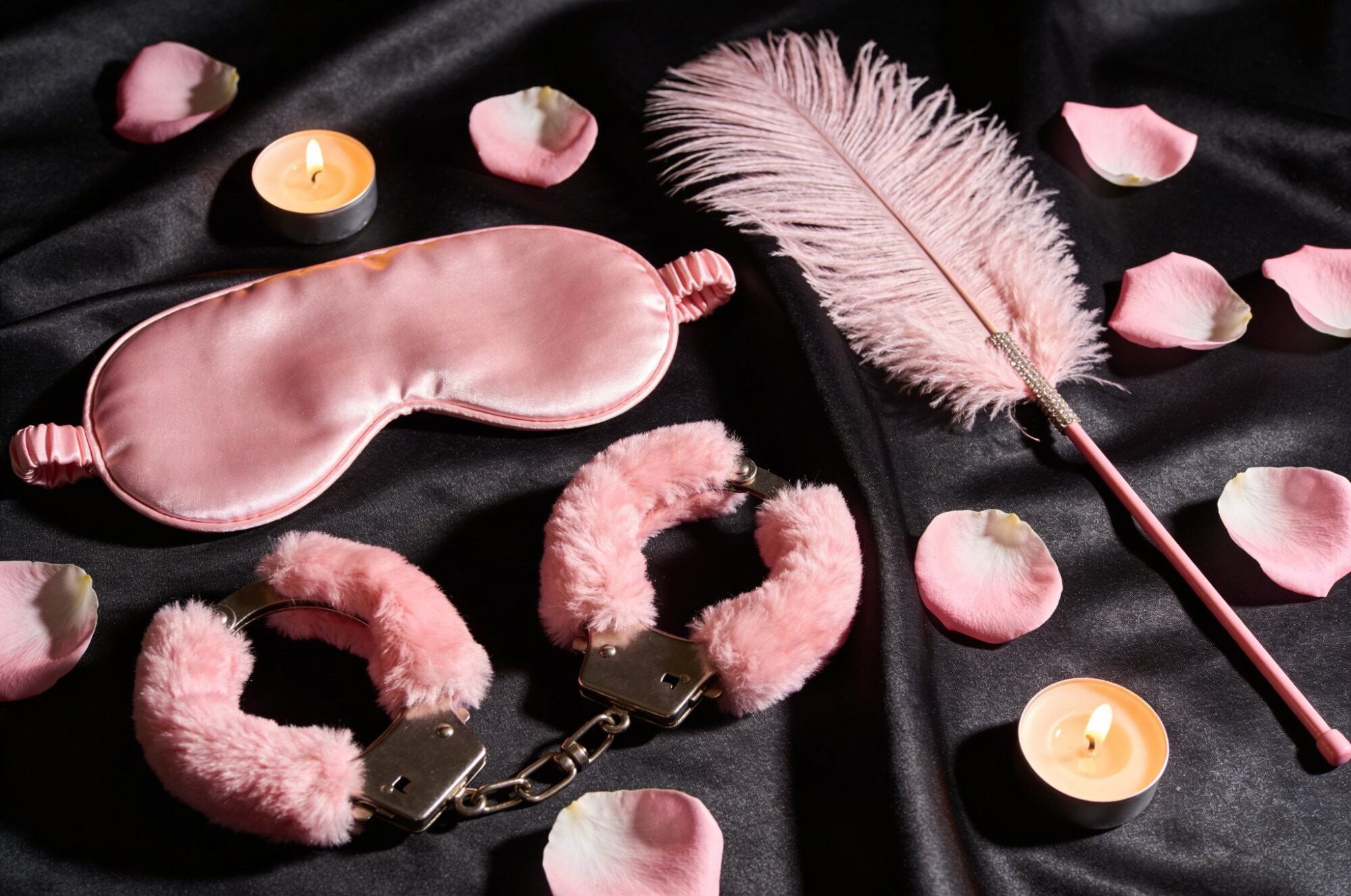 Accesorii BDSM pentru incepatori: catuse roz, masca satin si pana pe matase neagra cu petale | Erotica.ro